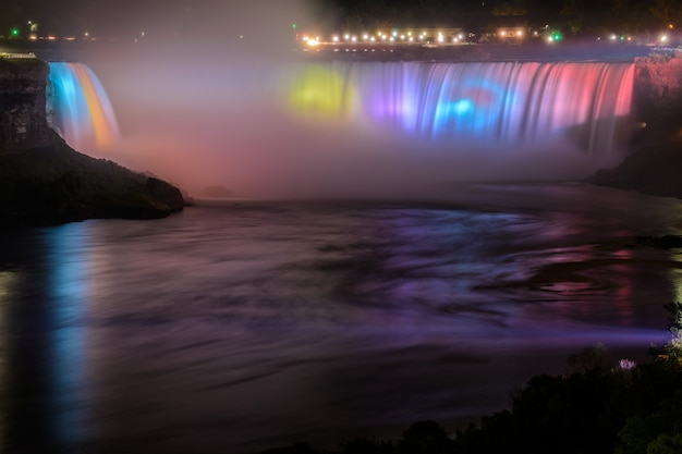 Niagara Falls lit at night by colorful lights