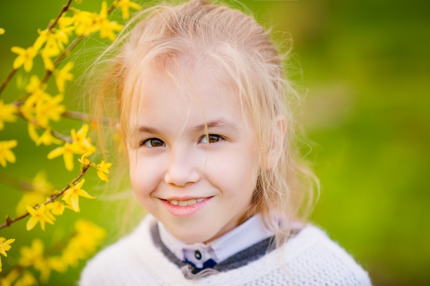 Nice blonde girl near the blossom tree