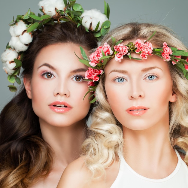 Nice Blonde Woman and Beautiful Brunette Model, Face Closeup. Girls in Flowers Wreath