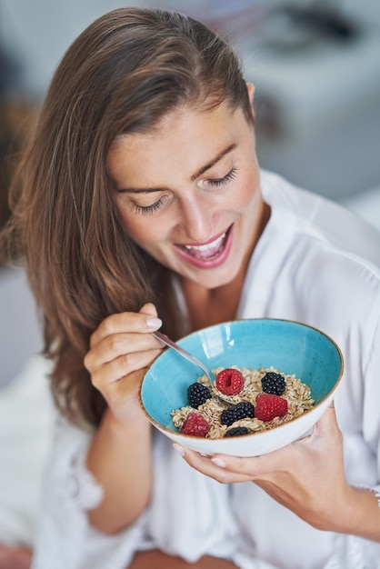 Nice brunette on bed wit cereal breakfast