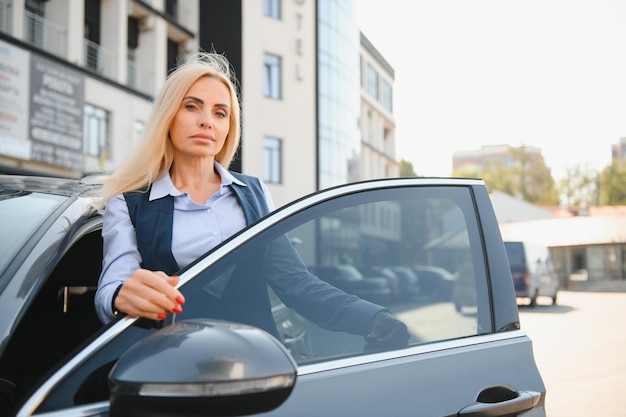 Nice business woman standing near automobile