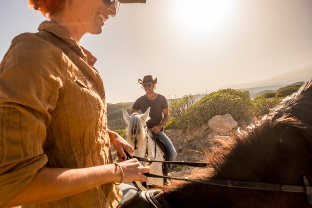 nice caucasian cowboys couple ride horses in wind ladscape scenic place