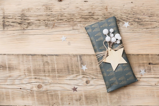 Nice Christmas gifts packed in black and striped paper and decorated with stars on wooden background