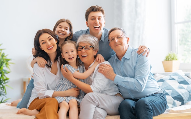 Nice girls, their mother, father, grandfather and grandmother are enjoying spending time together at home. Family time.