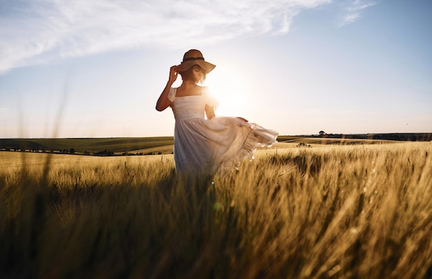 Nice landscape Beautiful young bride in white dress is on the agricultural field at sunny day