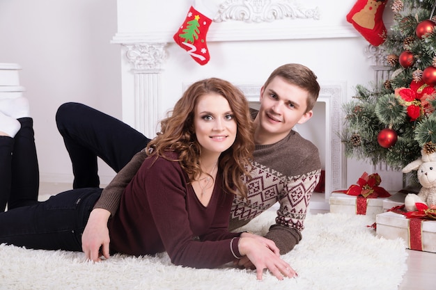 Nice love couple on carpet. Woman and man celebrating Christmas