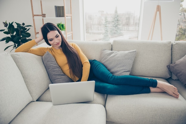 Nice lovely woman posing on the couch writing