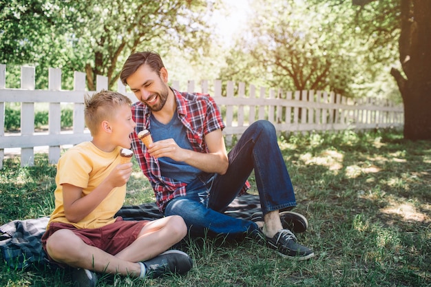 Nice picture of two guys sitting on blanket in park