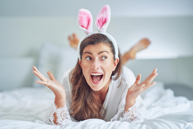 Nice and sexy brunette on bed with bunny ears