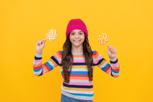 Nice smile hipster kid with colorful lollypop sugar candy on stick caramel candy shop sweet childhood life concept of dental care sweet tooth yummy happy teen girl hold lollipop lollipop lady