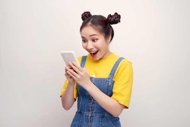 Nice vivid girlish happy smiling girl reading sms notification about winning isolated over white background