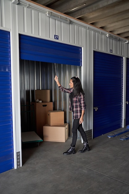 Nice woman closing or opening storage storage room for moving