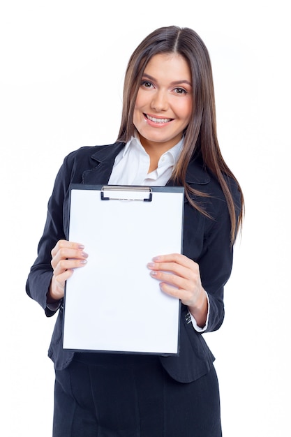 Nice young businesswoman holding blank paper sheet for copy space isolated on white wall