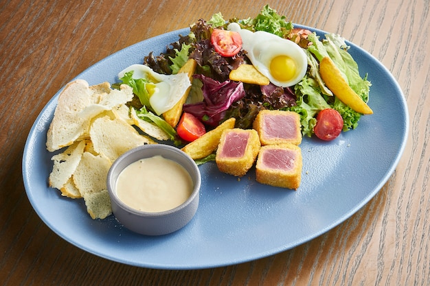 Nicoise salad with fresh tomatoes, asparagus, chili peppers, olives, quail eggs and fried tuna.