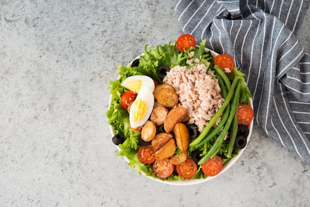 Nicoise salad with tuna, beans, vegetables and potatoes, top view, copy space