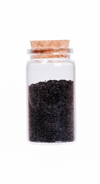 Nigella or Black cumin in a glass bottle with cork stopper isol