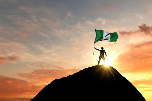 Nigeria flag being waved at the top of a mountain summit d rendering