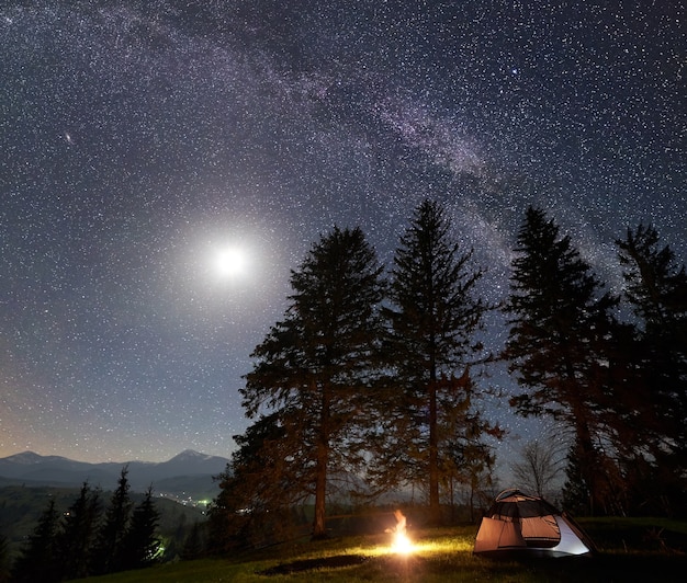 Night camping in mountains under starry sky and Milky way