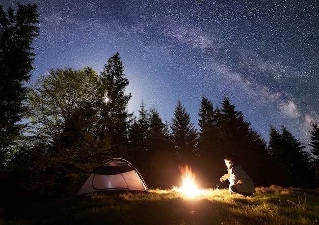 Night camping in mountains under starry sky and Milky way