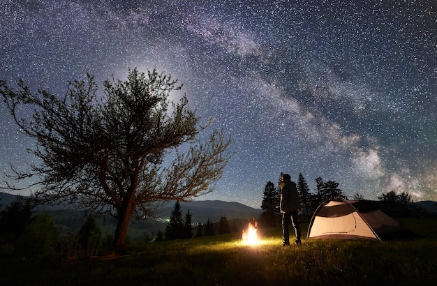 Night camping in mountains under starry sky and Milky way