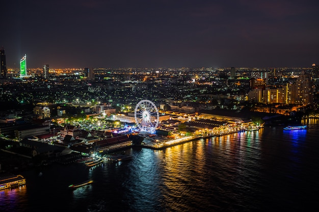 Night in city Bangkok and The Chao Phraya river view and Ferris wheel in Bangkok