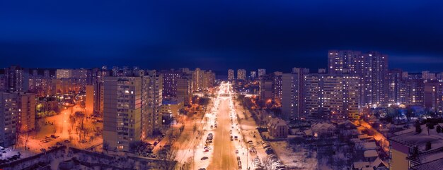 Night city neighborhood. Drone view. Colorful lights illuminate the streets and buildings. Wonderful city night landscape.