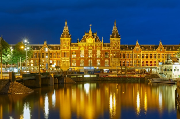 Night city view of Amsterdam canal and Centraal Station, Holland, Netherlands. Long exposure.