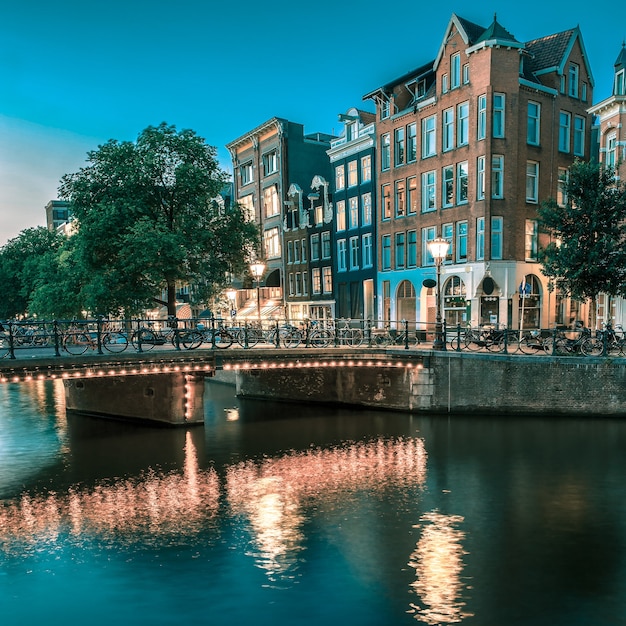 Night city view of Amsterdam canal houses and bridge Holland Netherlands