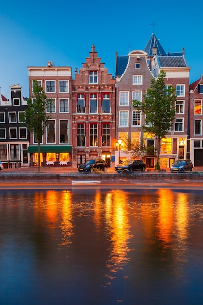 Night city view of Amsterdam canal with dutch houses