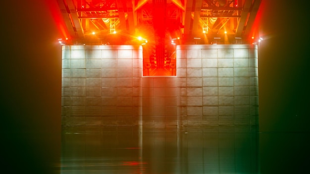 Night foggy view of the illuminated pillar of the bridge over the river