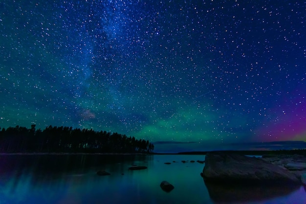 Night landscape with a starry sky and the milky way with stars and constellations over the water