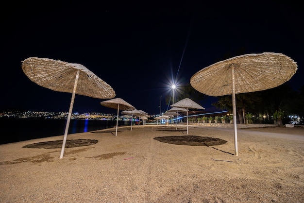 Night landscape with a view of the beach wicker umbrellas.