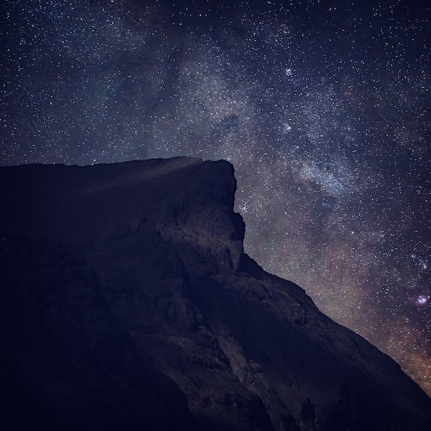 Night starry sky. Milky Way over a mountain peak.