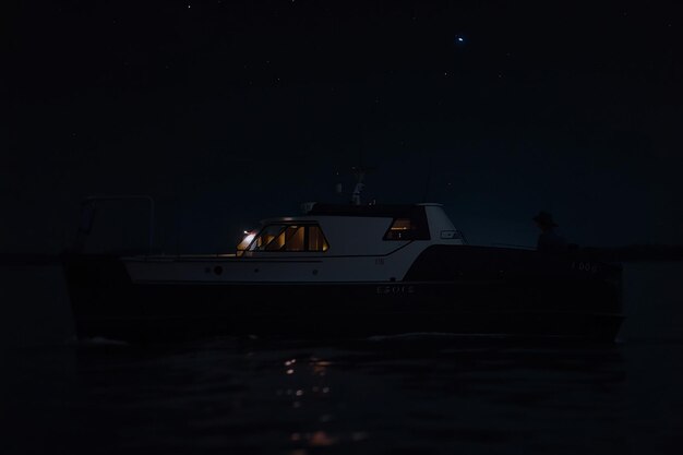 Night time and there are 2 people on a boat sea