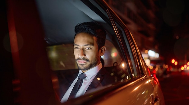 Night travel and business man in car relaxing commuting and traveling after working Transport road and young male professional passenger or businessman sitting in vehicle motor or taxi in city