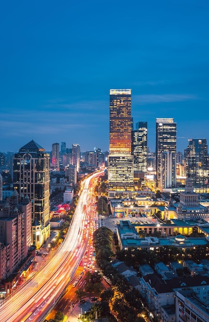 A night view of a city with a skyscraper and the word shanghai on the top.