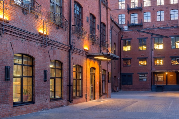 Night view. Modern Loft-style offices located in the old factory building. Red brick houses. Vintage. Buildings with large Windows