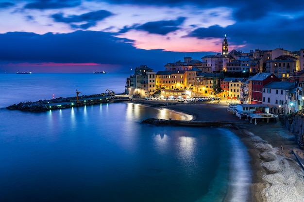 Night view of the old town of Bogliasco illuminated with lights reflecting on the sea