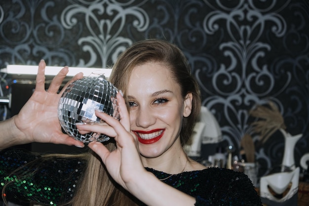 Nightlife new year eve party new year celebration portrait of young beautiful woman and disco ball