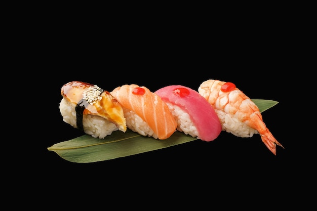 Nigiri sushi set nigiri eel salmon tuna shrimp on a banana leaf japanese food on isolated black background japanese menu