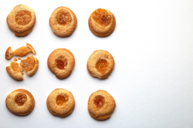 Nine handmade cookies with apricot jam arranged in even rows with free space