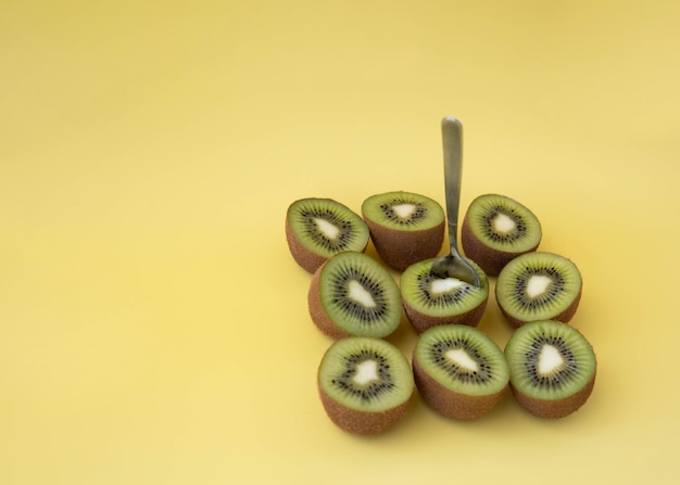 Nine kiwi halves with a small spoon the concept of etiquette and healthy eating