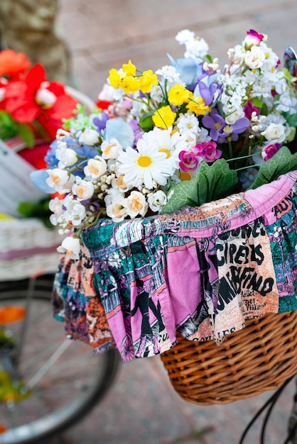 nnual women's bike parade Closeup of basket with white yellow and blue flowers decorates a bicycle