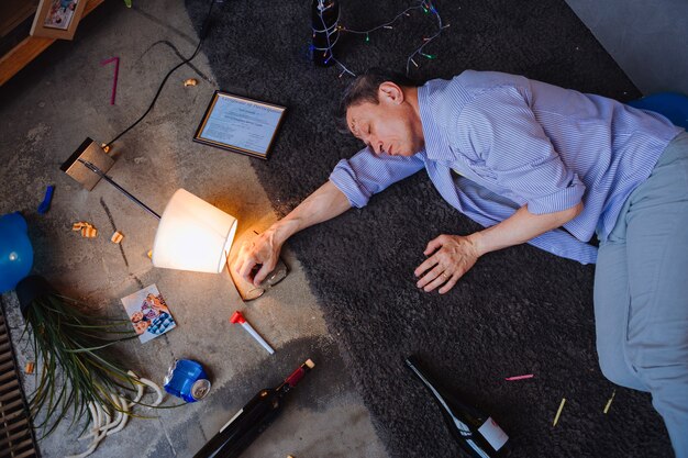 No alcohol limit. Calm mature man lying on floor and seeing dreams