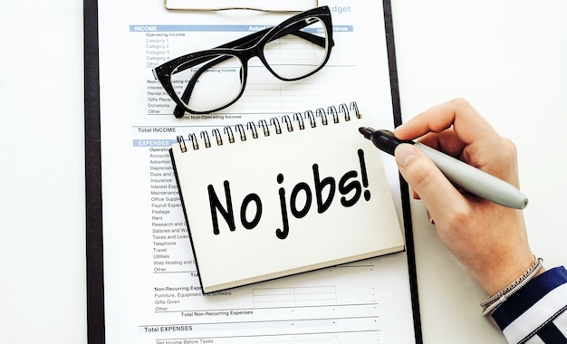 NO JOBS text written by business woman in her diary on office deskBusiness concept