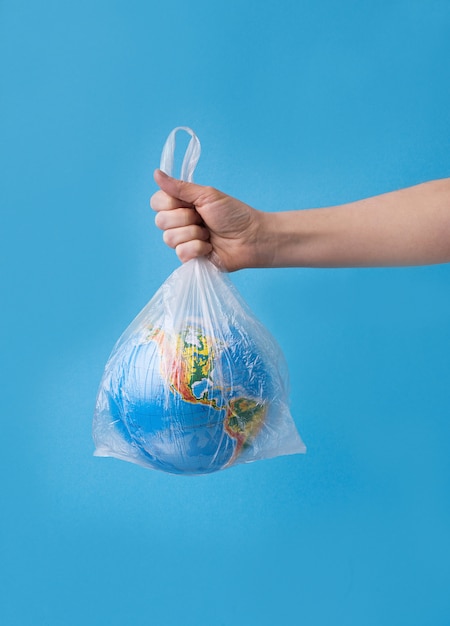 No plastic concept. hands holding planet earth in plastic bag.