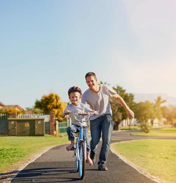 No training wheels needed Shot of a father teaching his little son how to ride a bicycle in the park