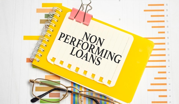 NON PERFORMING LOANS words on yellow notepad and charts