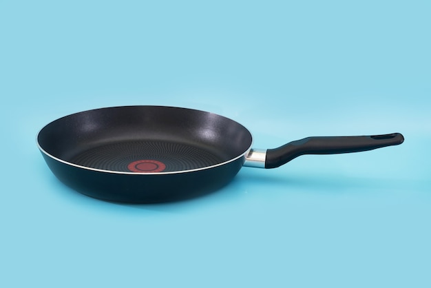 Non-stick frying pan isolated on blue background.