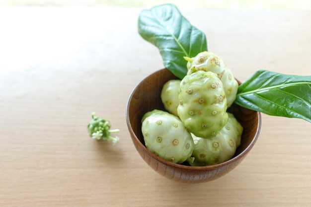 Noni or Morinda citrifolia, great morinda, Indian mulberry, beach mulberry, or cheese fruit on wood table